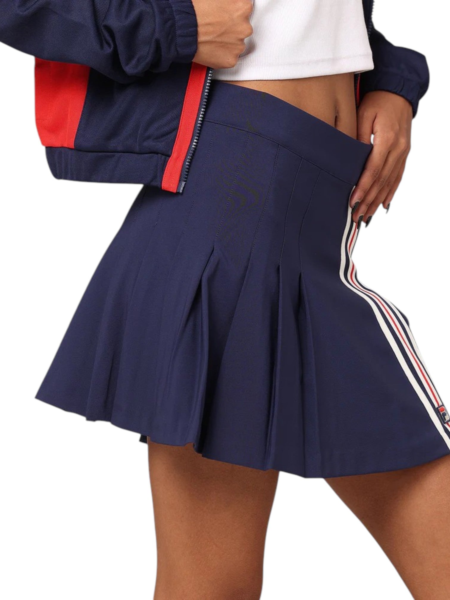 Navy pleated skirt with red and white side stripes worn by a person on a white background. Fila, Monza Outlet, Monza Fashion, Shein Outlet