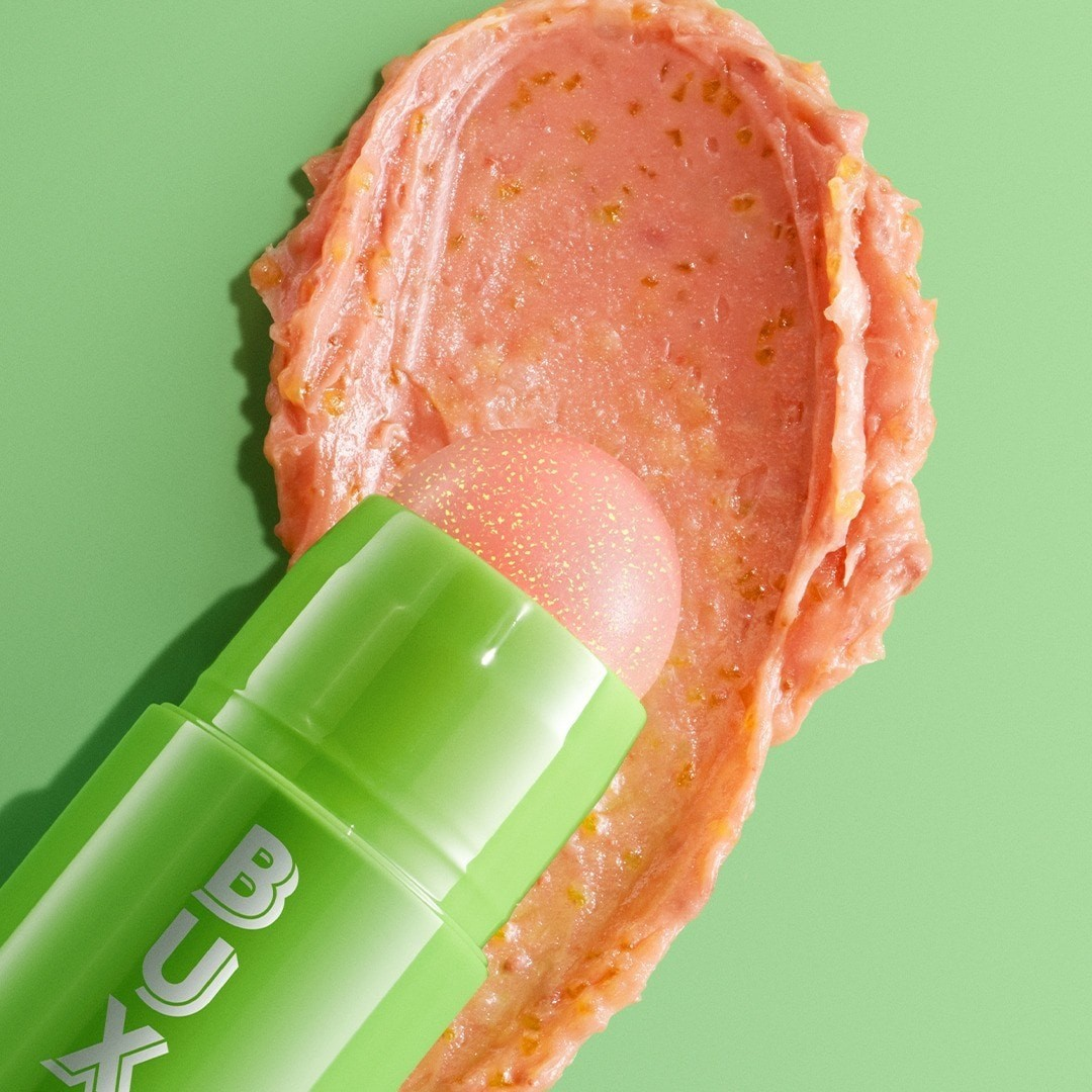 Green lip balm with pink substance on a green background Monza fashion outlet, monza outlet, shein outlet, shien outlet cosmetics, makeup, perfume