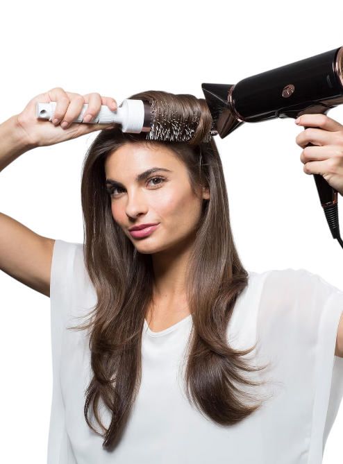 Woman using a hair dryer and round brush on her hair against a white background T3 Monza Outlet