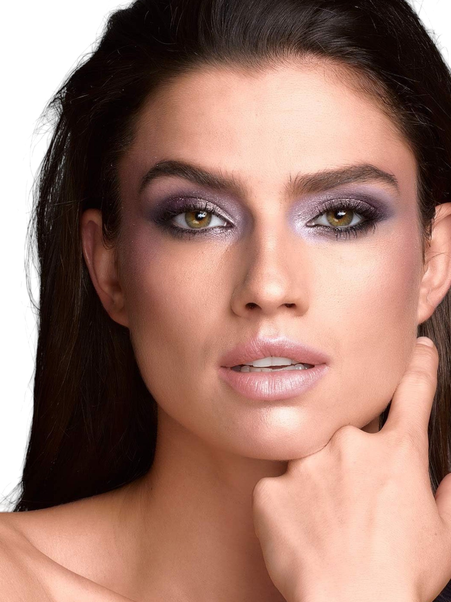 Close-up of a woman with dramatic makeup and a hand on her face against a white background Maybelline Monza Outlet