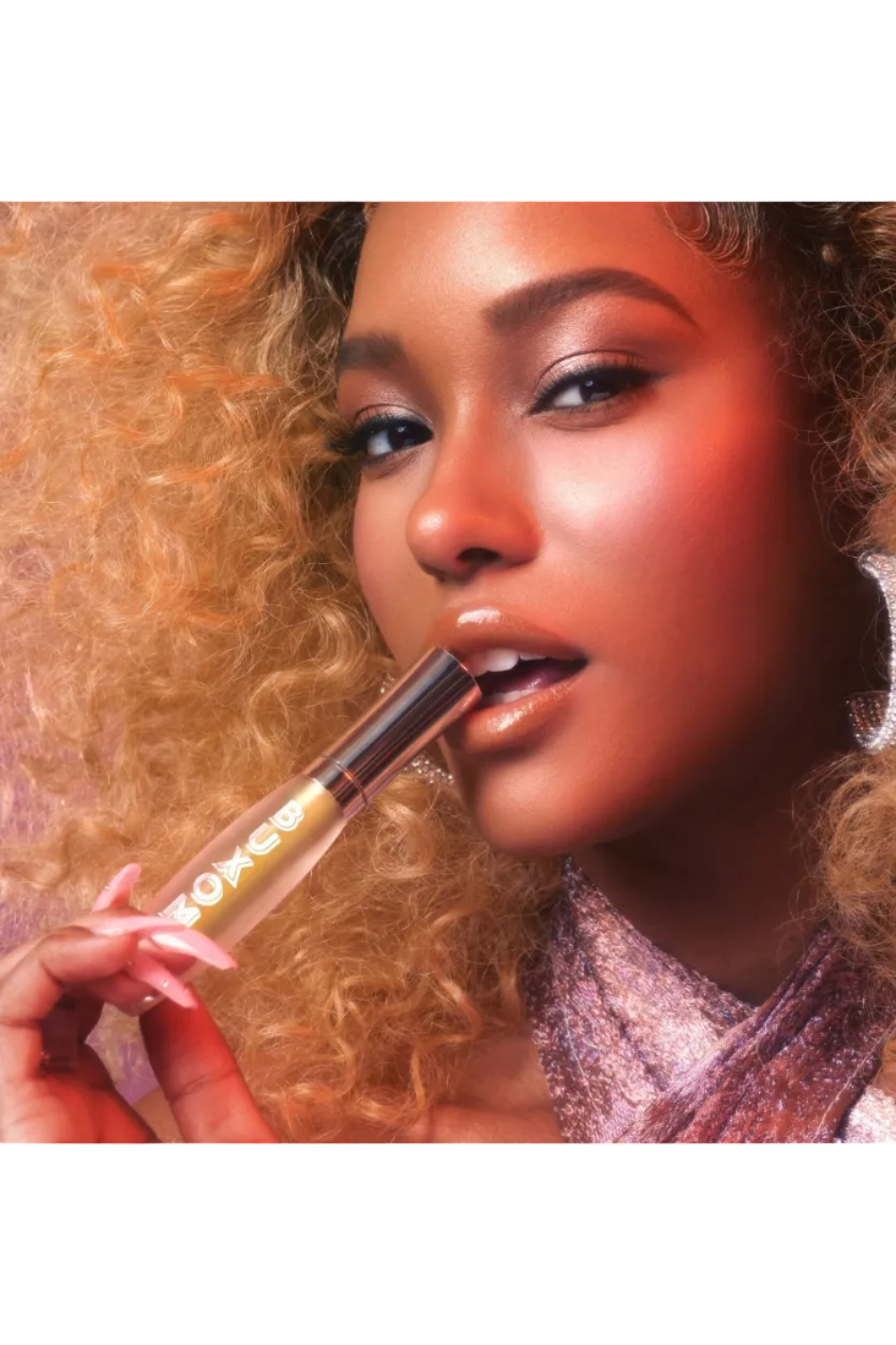 Woman holding a lip gloss with a colorful background Monza fashion outlet, monza outlet, shein outlet, shien outlet cosmetics, makeup, perfume