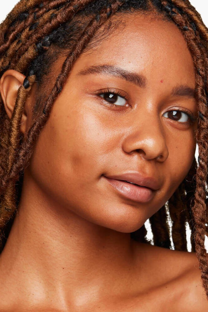 Close-up of a woman with braided hair on a white background Monza fashion outlet, monza outlet, shein outlet, shien outlet cosmetics, makeup, perfume