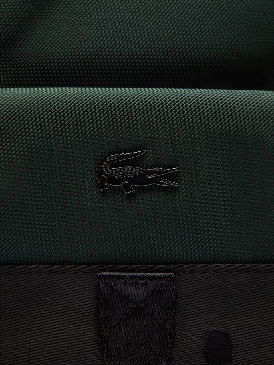 Close-up of a green bag with a crocodile logo on a dark background Lacoste Monza Outlet, Monza Fashion, Shein Outlet