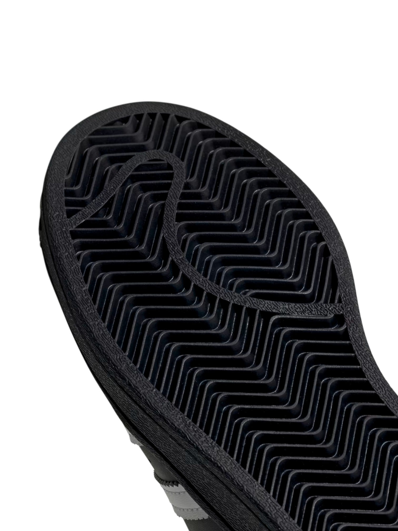 Close-up of a black shoe sole with tread pattern on a white background. Adidas, Monza Outlet, Monza Fashion, Shein Outlet