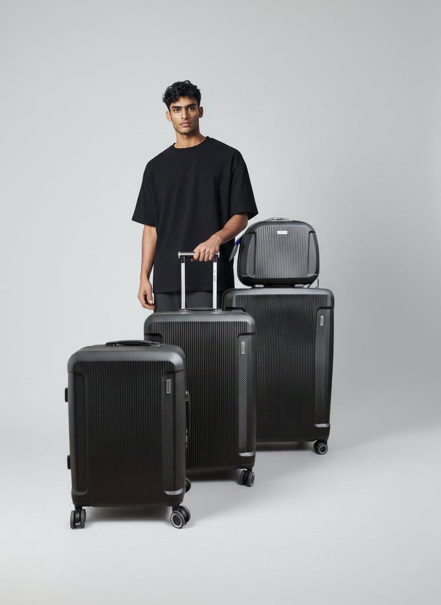 Man standing with three black suitcases on a light gray background. Monza Italy, Monza Outlet, Monza Fashion, Shein Outlet