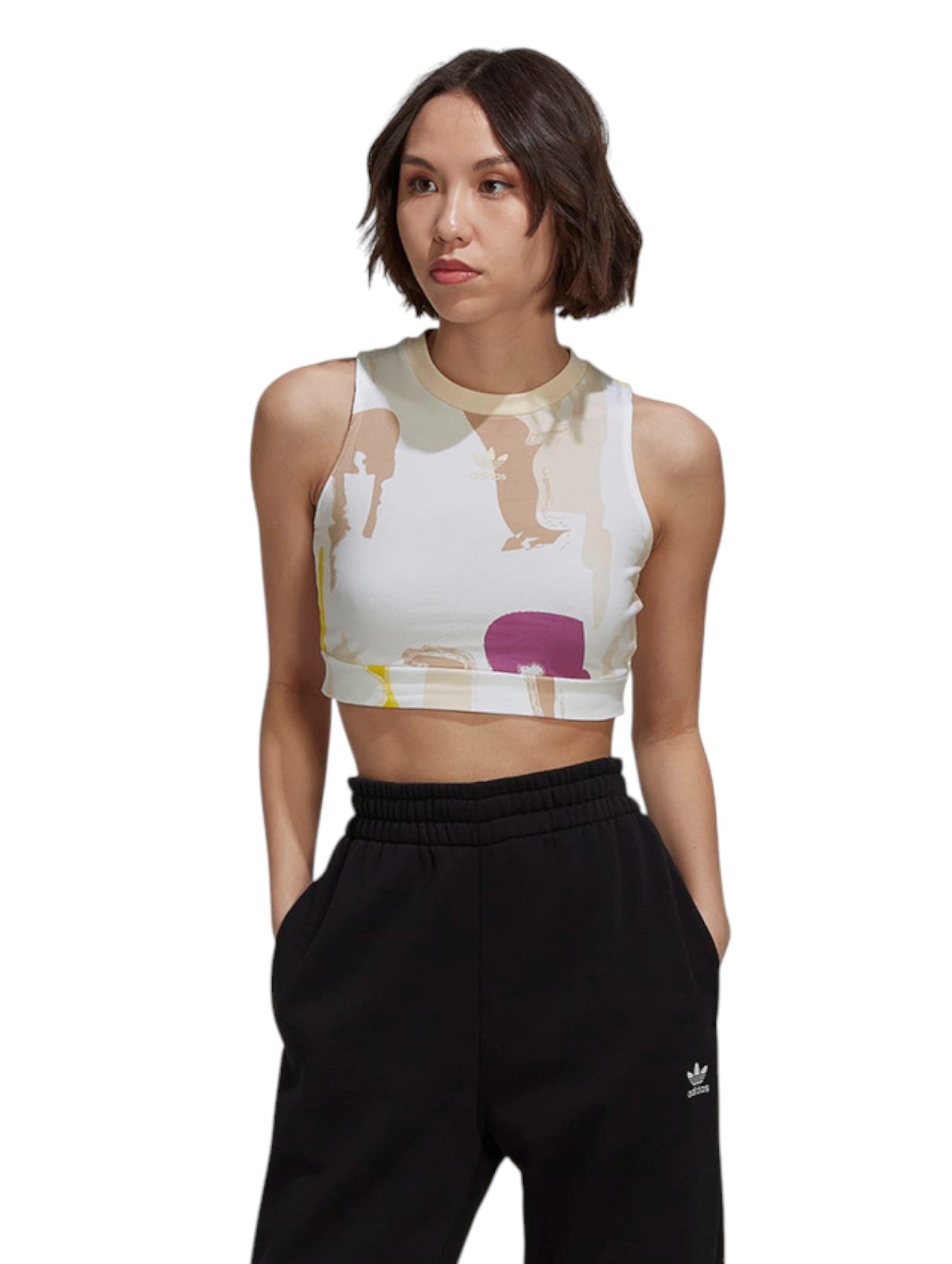 Woman wearing a colorful sports bra and black Adidas pants on a white background. Adidas, Monza Outlet, Monza Fashion, Shein Outlet