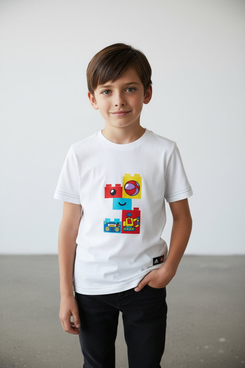 Child wearing a white t-shirt with colorful graphic design on a plain background. Adidas, Monza Outlet, Monza Fashion, Shein Outlet