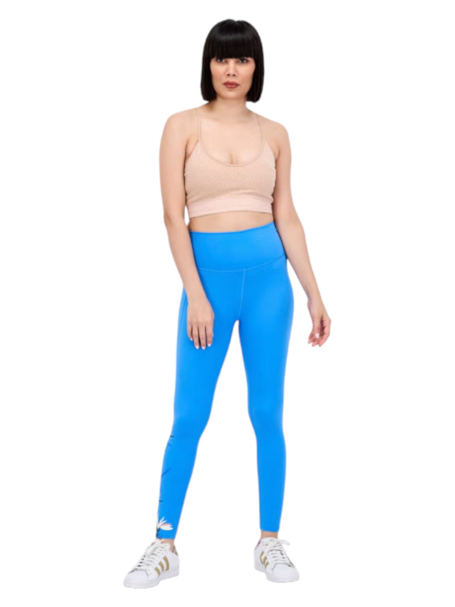Woman wearing blue leggings and a beige top on a white background. Adidas, Monza Outlet, Monza Fashion, Shein Outlet