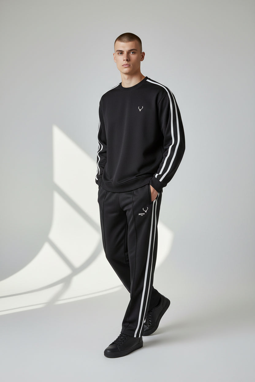 Person wearing a black tracksuit with white stripes on a light gray background. Antler, Monza Outlet, Monza Fashion, Shein Outlet