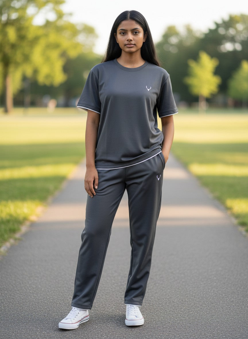 Person wearing a gray athletic outfit standing on a path in a park. Antler, Monza Outlet, Monza Fashion, Shein Outlet 