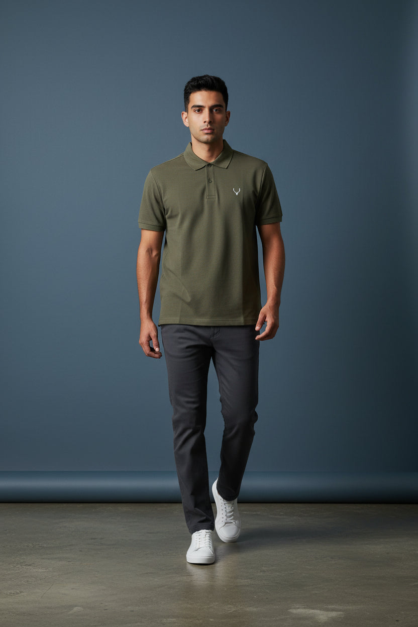 Man wearing a red polo shirt with a small black logo, dark gray pants, and white shoes against a gray background. Antler, Monza Outlet, Monza Fashion, Shein Outlet 