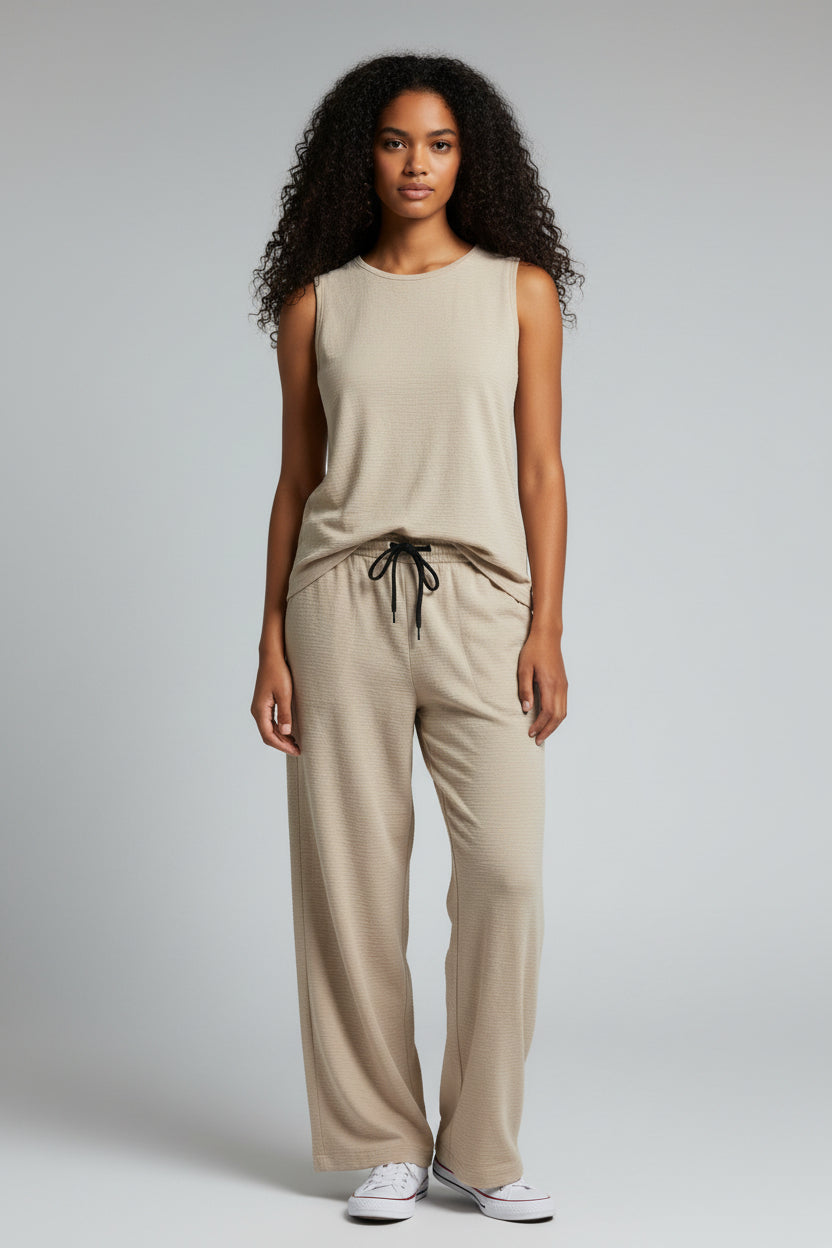 Woman wearing a beige sleeveless top and pants on a gray background. Antler, Monza Outlet, Monza Fashion, Shein Outlet