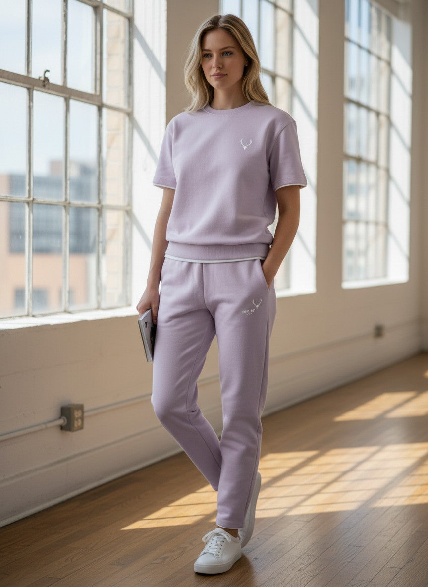 Woman wearing a light purple outfit with a logo in a bright room. Antler, Monza Outlet, Monza Fashion, Shein Outlet 