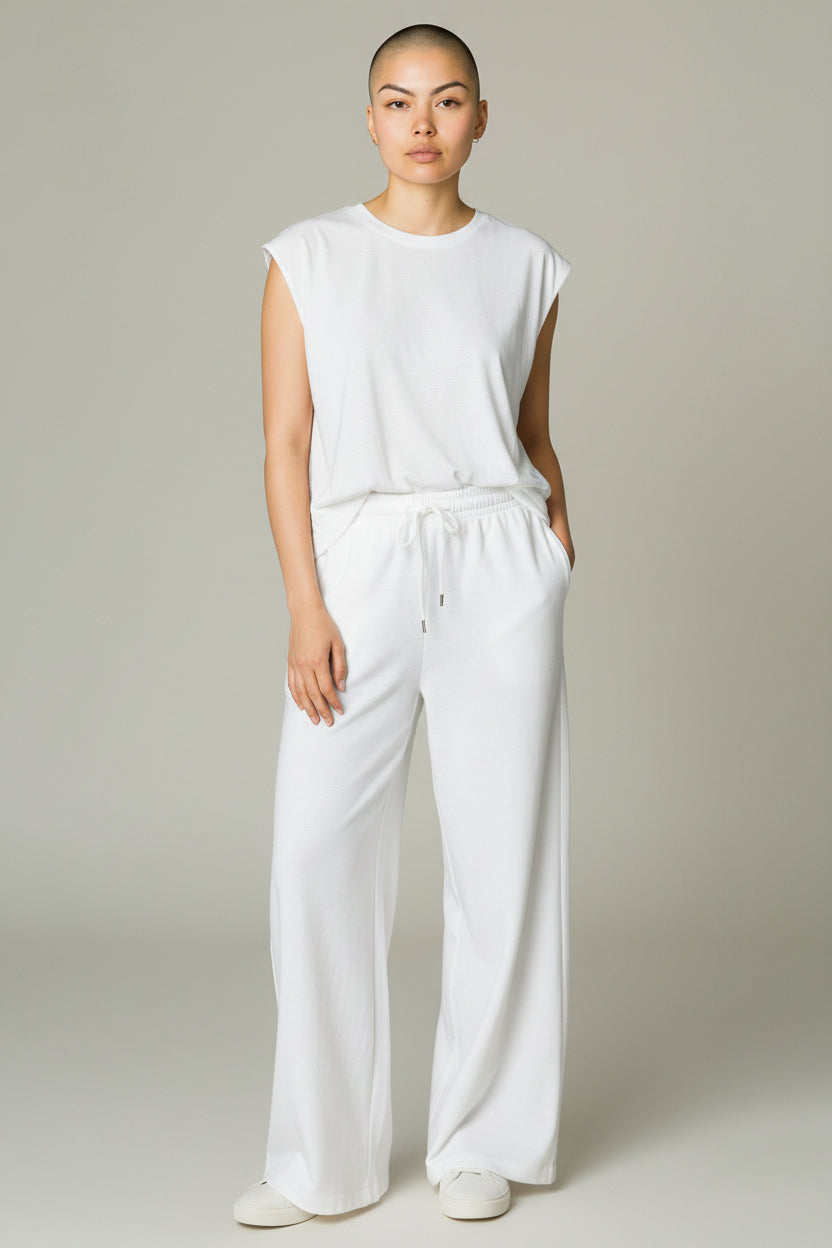 Person wearing a white sleeveless top and pants against a plain background. Antler, Monza Outlet, Monza Fashion, Shein Outlet