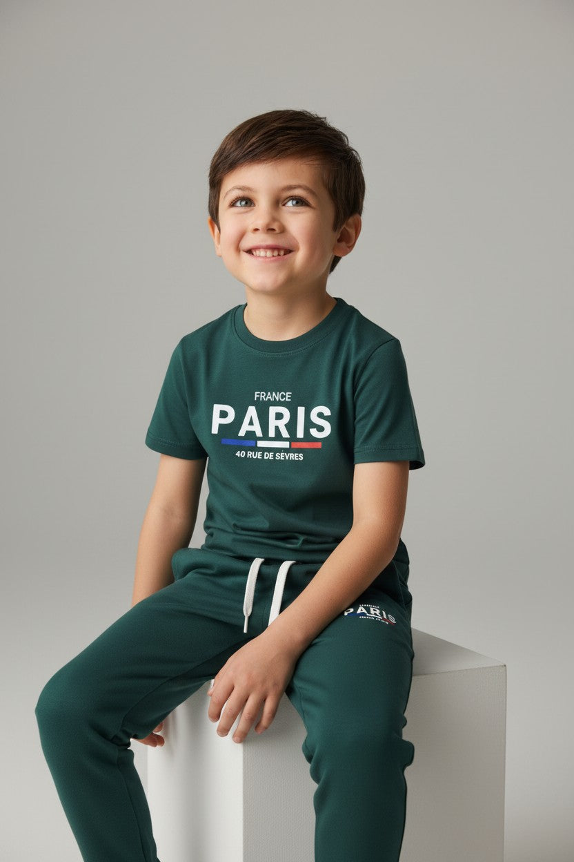 Child wearing a green France Paris t-shirt and pants on a gray background. Antler, Monza Outlet, Monza Fashion, Shein Outlet