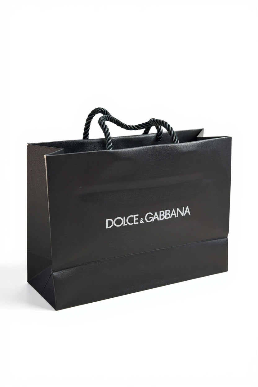 Black Dolce & Gabbana shopping bag on a white background. Dolce & Gabbana, Monza Outlet, Monza Fashion, Shein Outlet