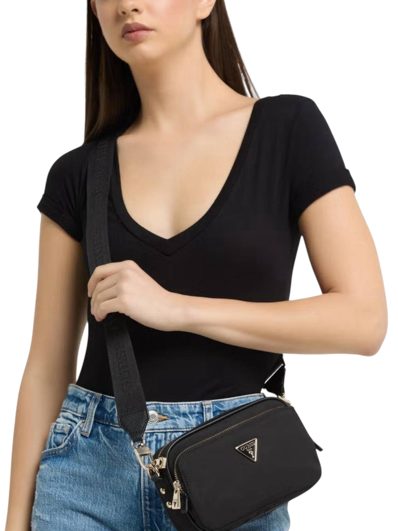Woman holding a black crossbody bag with a brand logo on a white background. Guess, Monza Outlet, Monza Fashion, Shein Outlet
