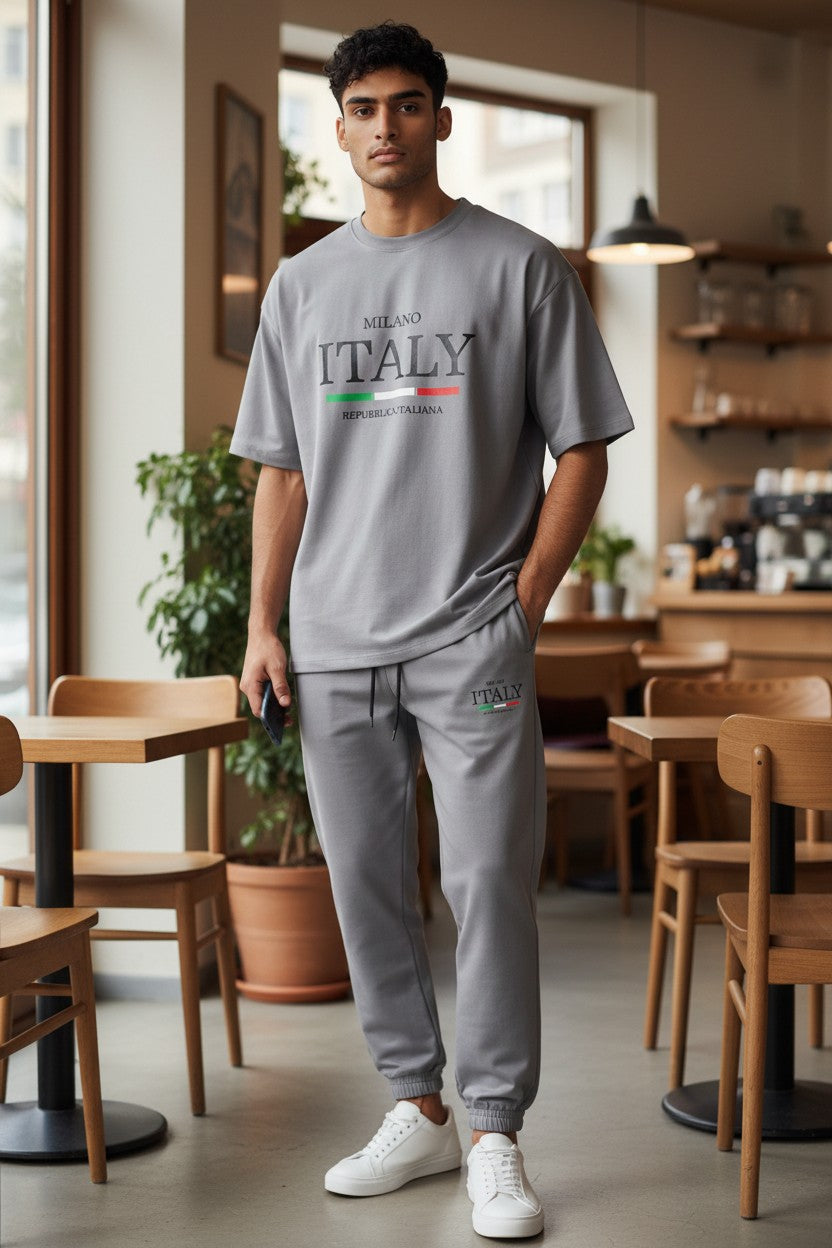 Man wearing a gray Milano Italy t-shirt in a cafe setting. Antler, Monza Outlet, Monza Fashion, Shein Outlet