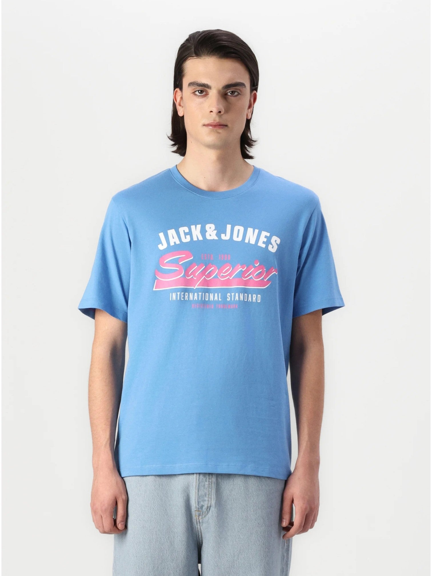 Person wearing a blue 'Jack & Jones' t-shirt with pink text on a white background.  Jack & Jones, Monza Outlet, Monza Fashion, Shein Outlet 