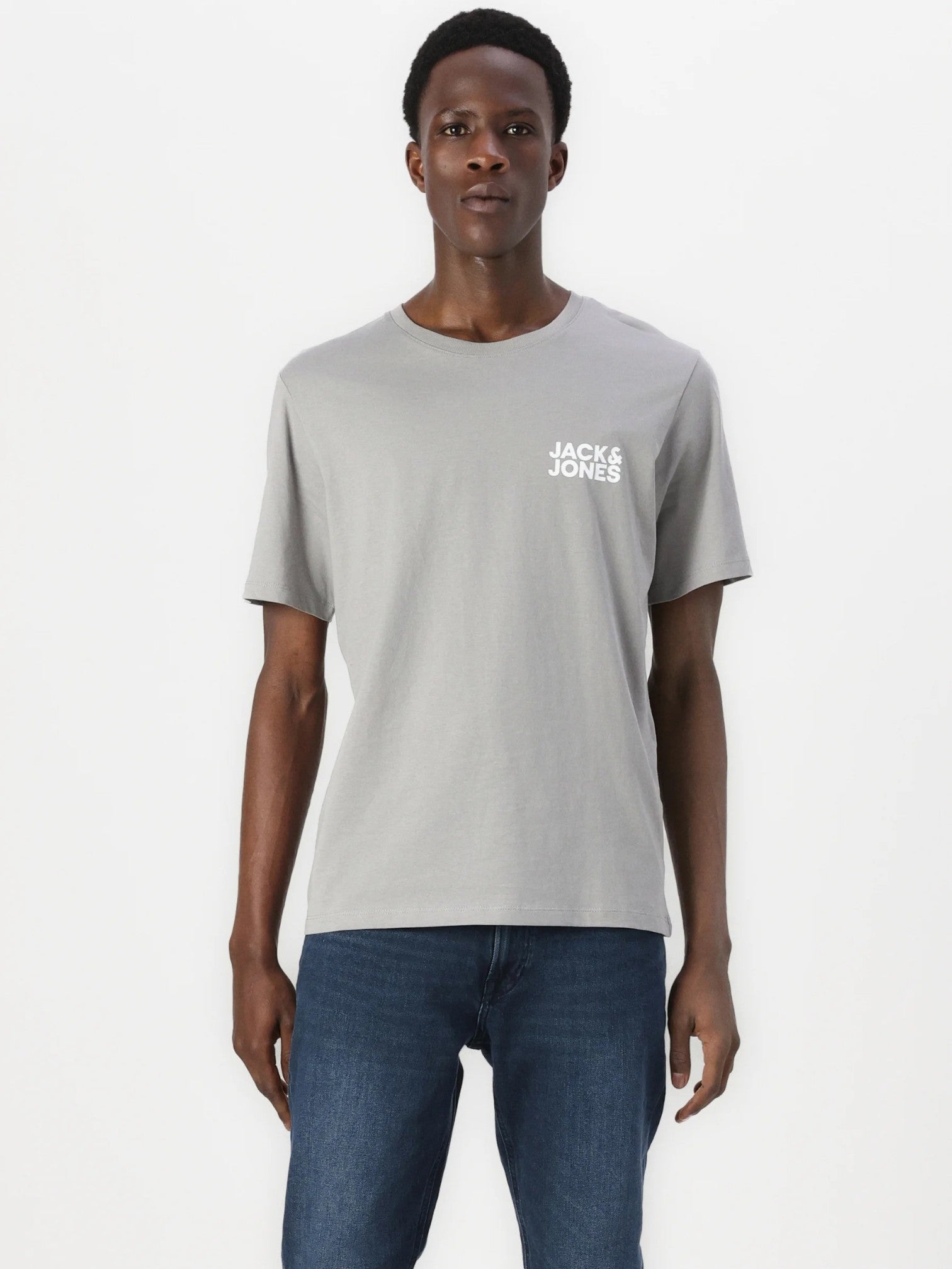 Man wearing a gray 'Jack & Jones' t-shirt and blue jeans on a white background. Jack & Jones, Monza Outlet, Monza Fashion, Shein Outlet 