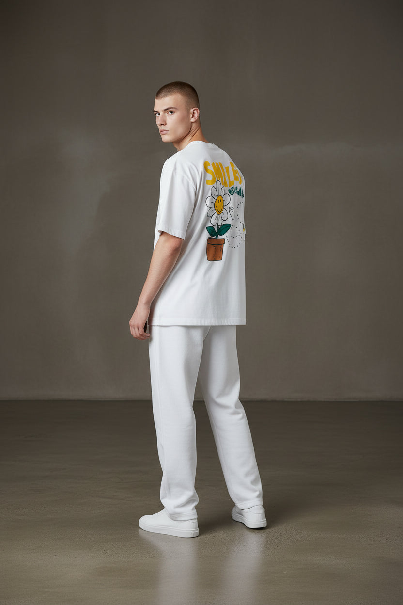 Person wearing a white t-shirt with a graphic design on a plain background. Monza Outlet, Monza Fashion, Shein Outlet