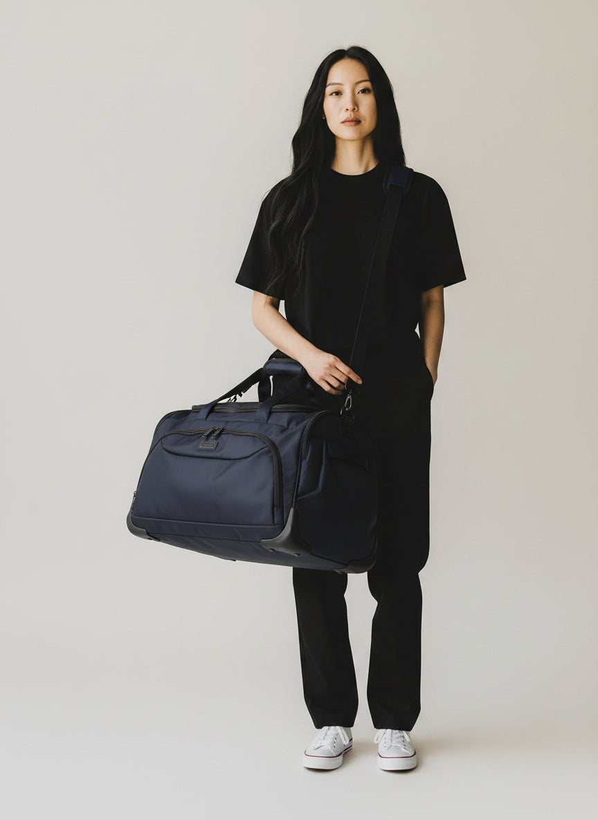 Person holding a navy duffel bag against a plain background. Monza Italy, Monza Outlet, Monza Fashion, Shein Outlet 