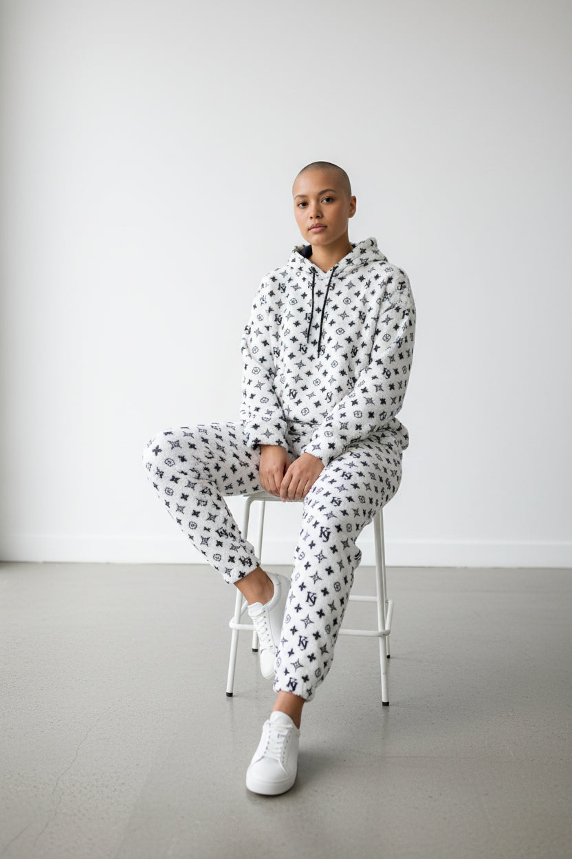 Person wearing a patterned onesie sitting on a stool against a white background. Antler, Monza Outlet, Monza Fashion, Shein Outlet