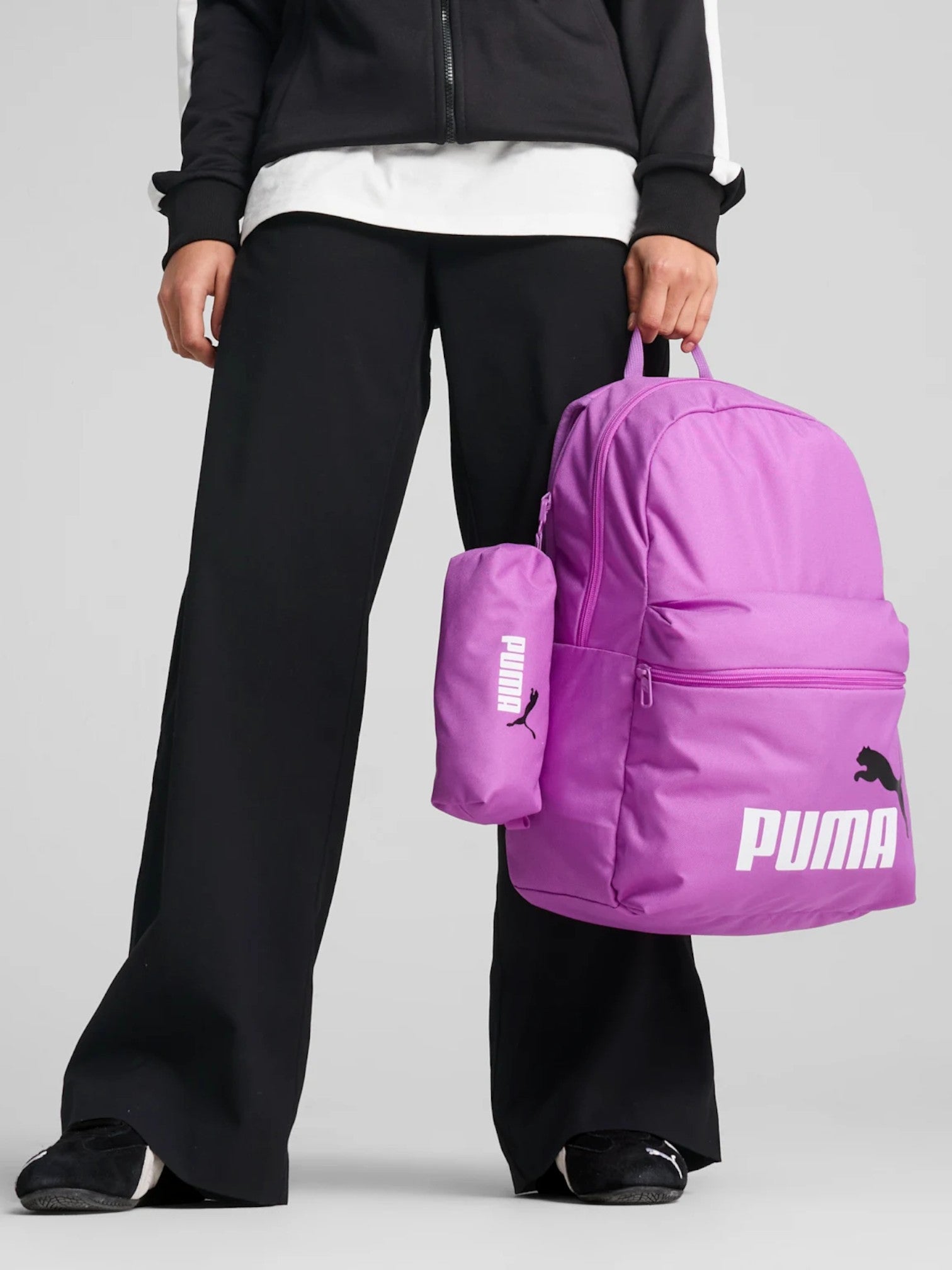 Person holding a purple Puma backpack against a gray background. Puma, Monza Outlet, Monza Fashion, Shein Outlet
