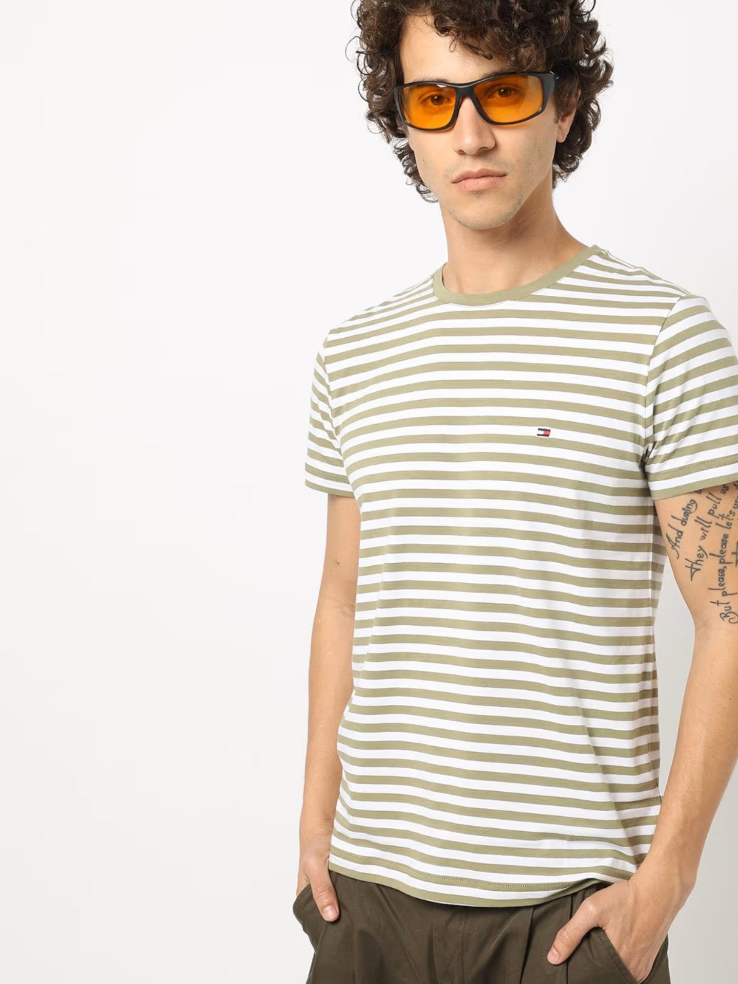 Man wearing a striped t-shirt and sunglasses on a plain background. Tommy, Monza Outlet, Monza Fashion, Shein Outlet