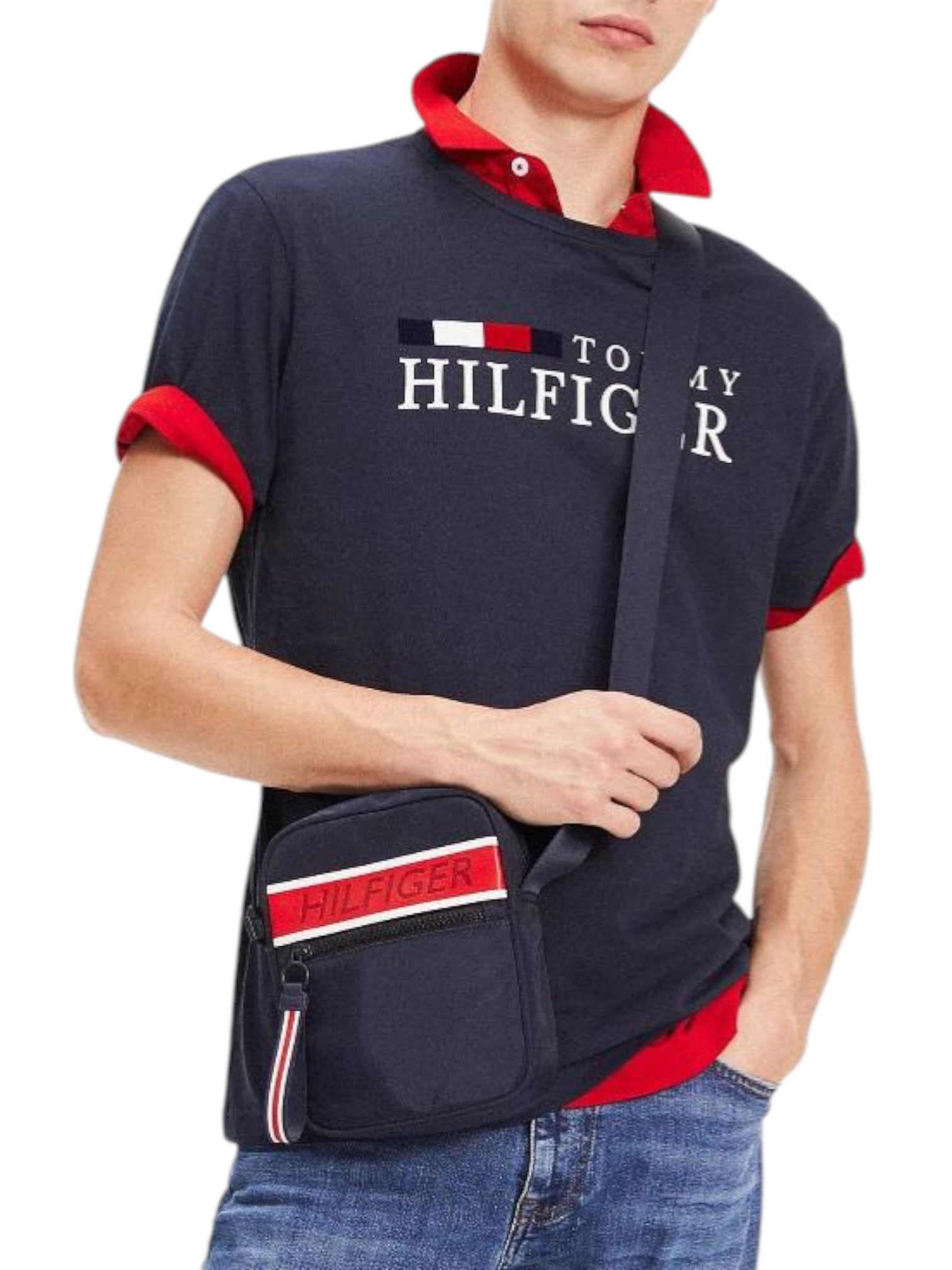Person wearing a Tommy Hilfiger polo shirt and holding a matching bag on a white background. Tommy Hilfiger, Monza Outlet, Monza Fashion, Shein Outlet