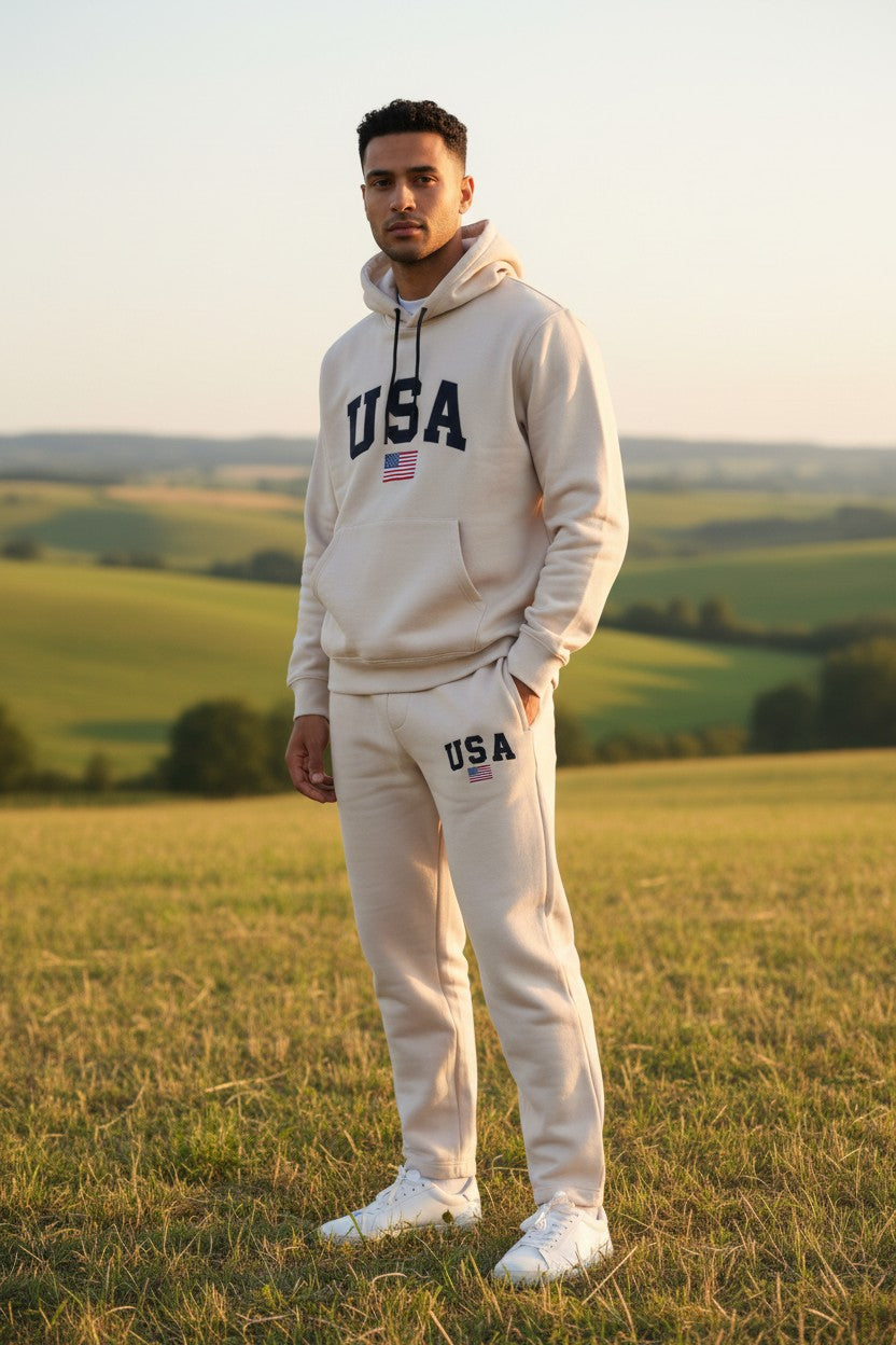 Man wearing a beige USA hoodie and pants standing in a field. Antler, Monza Outlet, Monza Fashion, Shein Outlet