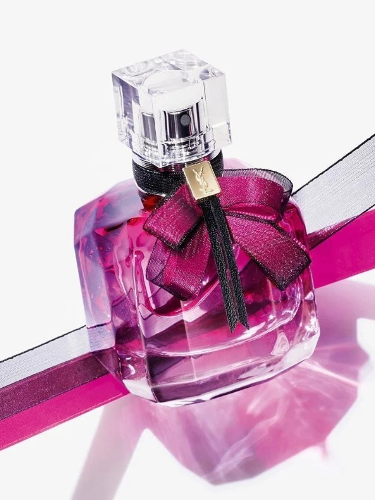 Perfume bottle with a pink ribbon on a white background. Yves Saint Laurent, Monza Outlet, Monza Fashion, Shein Outlet