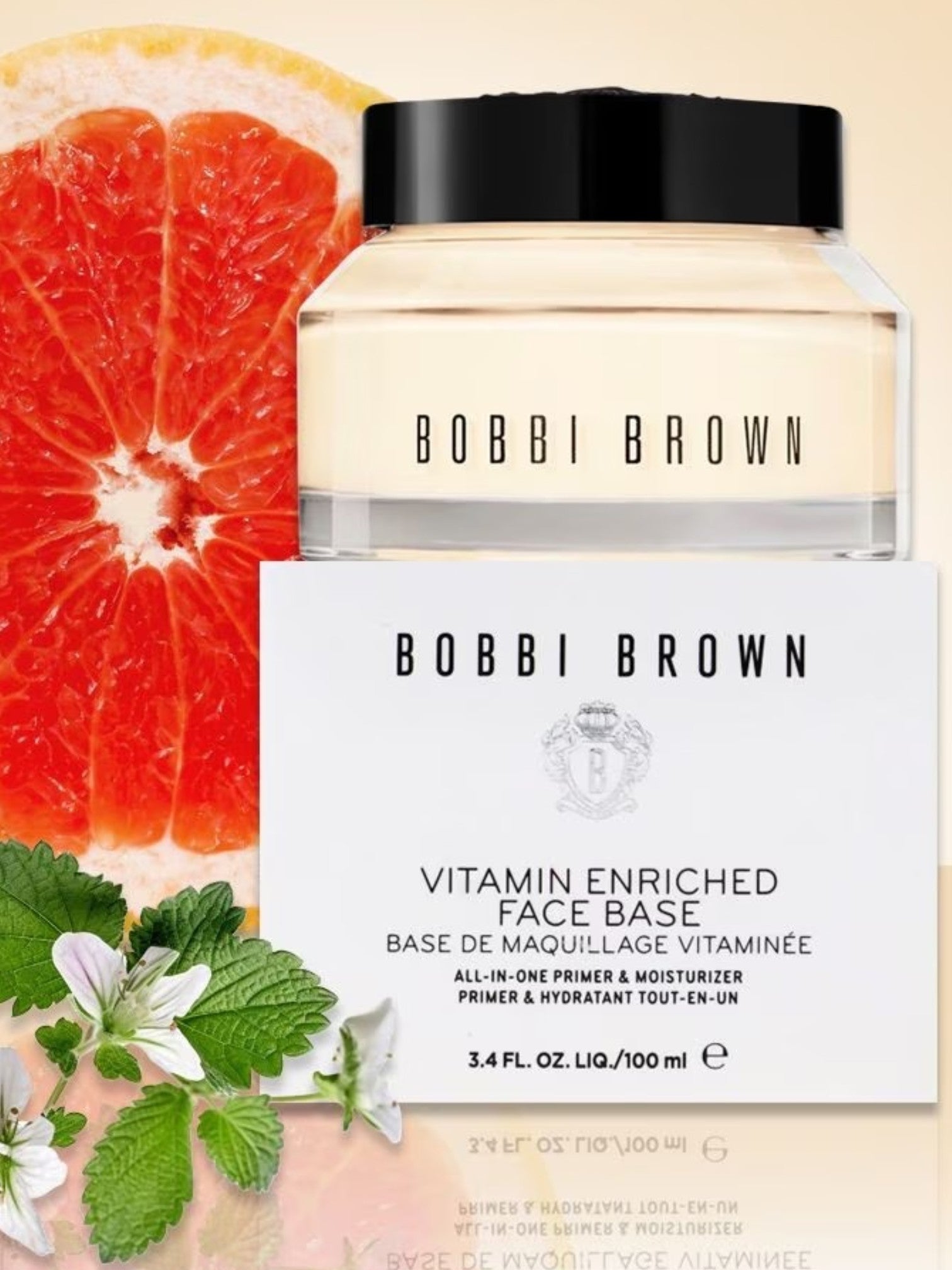 Bobbi Brown Vitamin Enriched Face Base with a grapefruit slice and green leaves on a beige background. Bobbi Brown, Monza Outlet, Monza Fashion, Shein Outlet