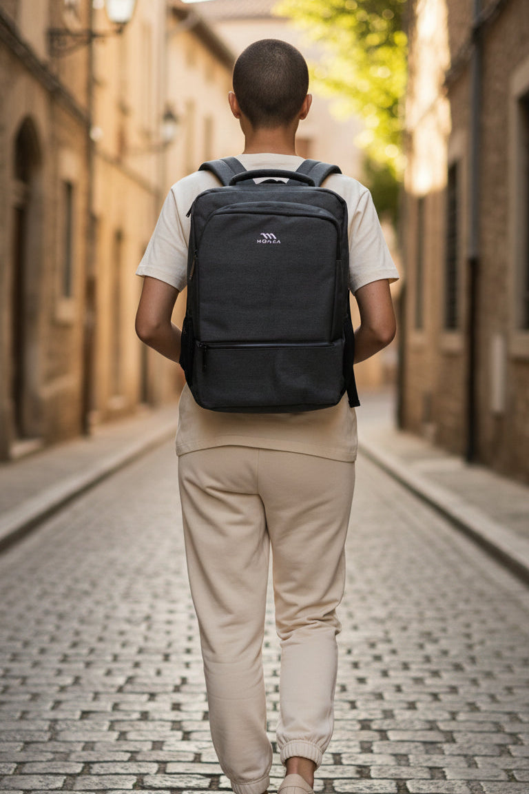 Person walking down a cobblestone street with a black backpack. Monza Italy, Monza Outlet, Monza Fashion, Shein Outlet