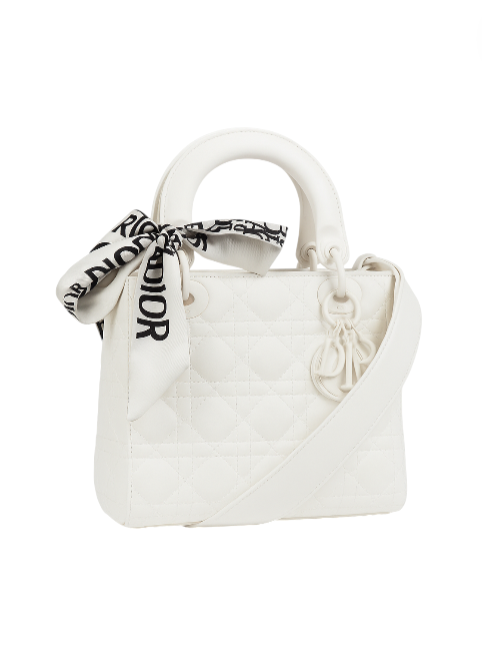 White handbag with a black and white scarf on a white background. Dior Monza Outlet