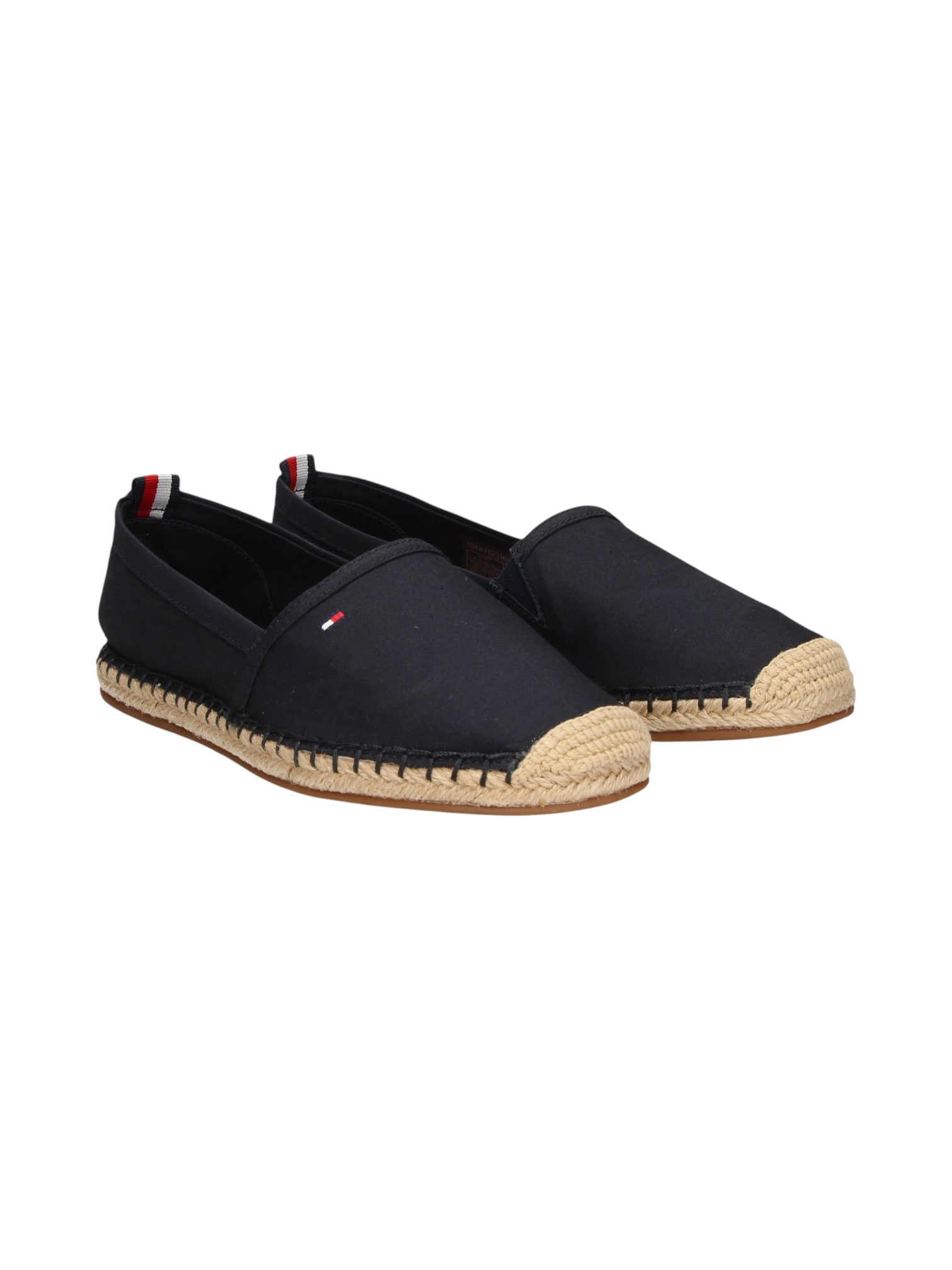 A pair of black canvas espadrille slip on shoes with natural jute-wrapped soles and a small red, white, and blue Tommy Hilfiger flag logo on the side, shown against a plain white background. Tommy Hilfiger, Monza Outlet, Monza Fashion, Shein Outlet