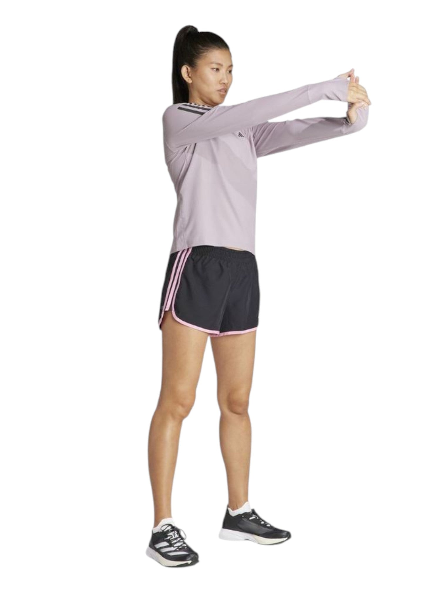 Woman in athletic wear stretching on a white background. Adidas, Monza Outlet, Monza Fashion, Shein Outlet