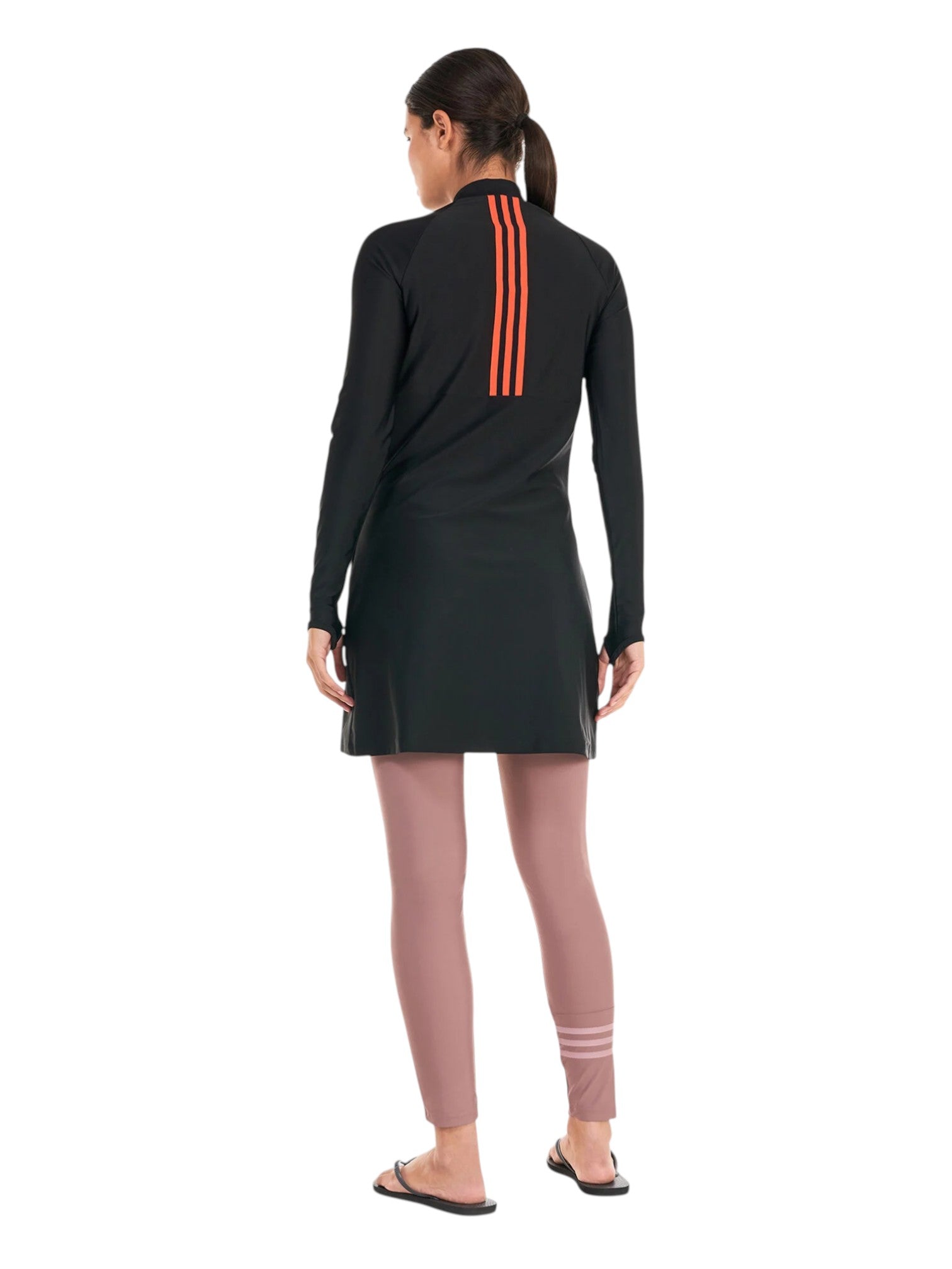 Person wearing a black long-sleeve top with orange stripes and pink leggings on a white background. Adidas, Monza Outlet, Monza Fashion, Shein Outlet