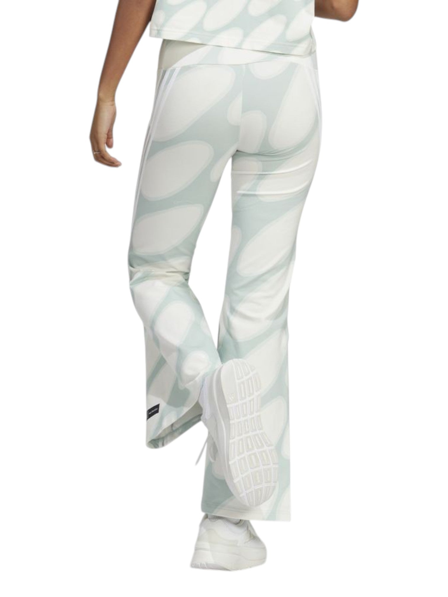 Person wearing light gray patterned pants and white sneakers on a white background. Adidas, Monza Outlet, Monza Fashion, Shein Outlet