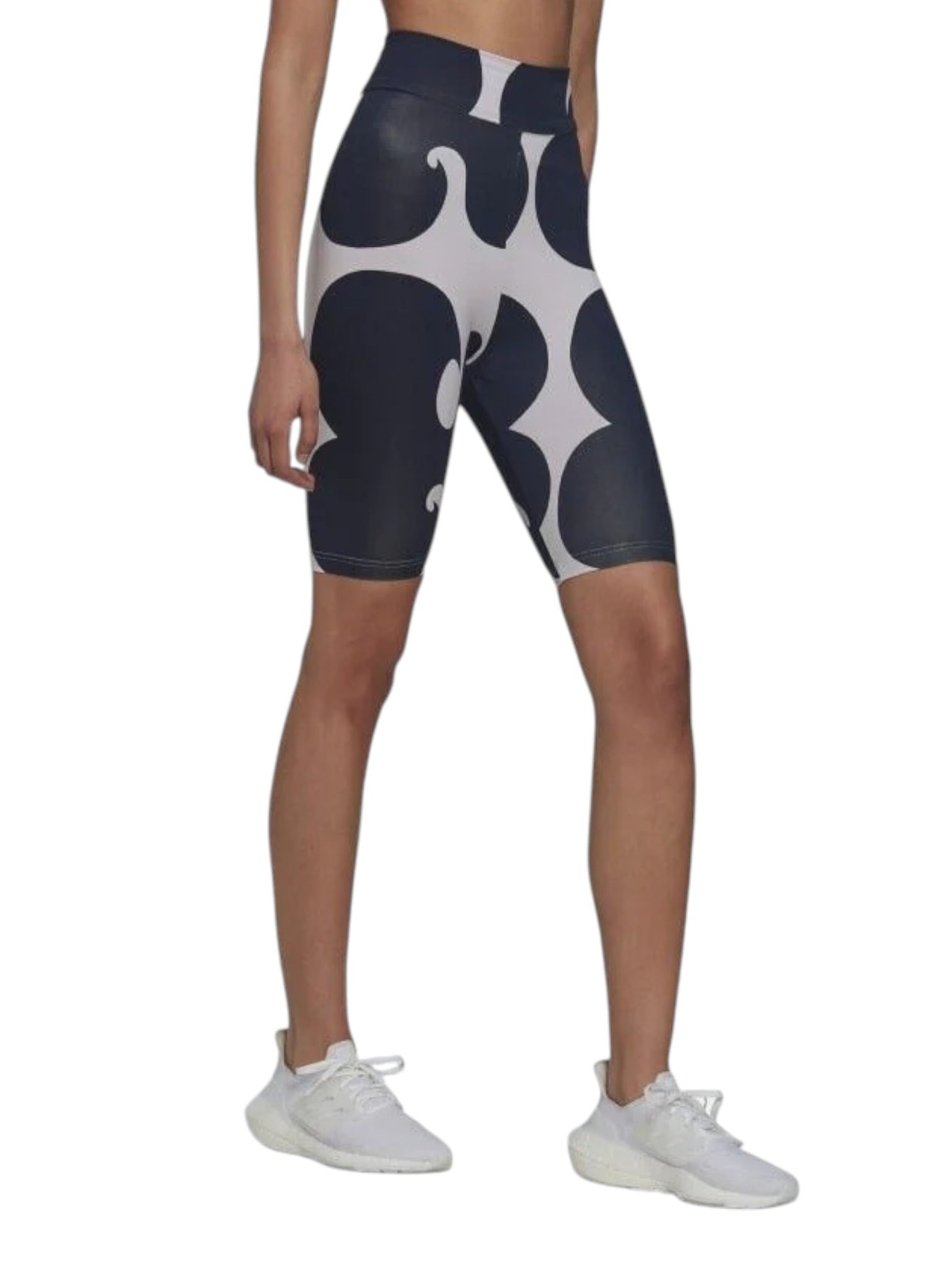 Person wearing black and white patterned leggings with white sneakers on a white background. Adidas, Monza Outlet, Monza Fashion, Shein Outlet