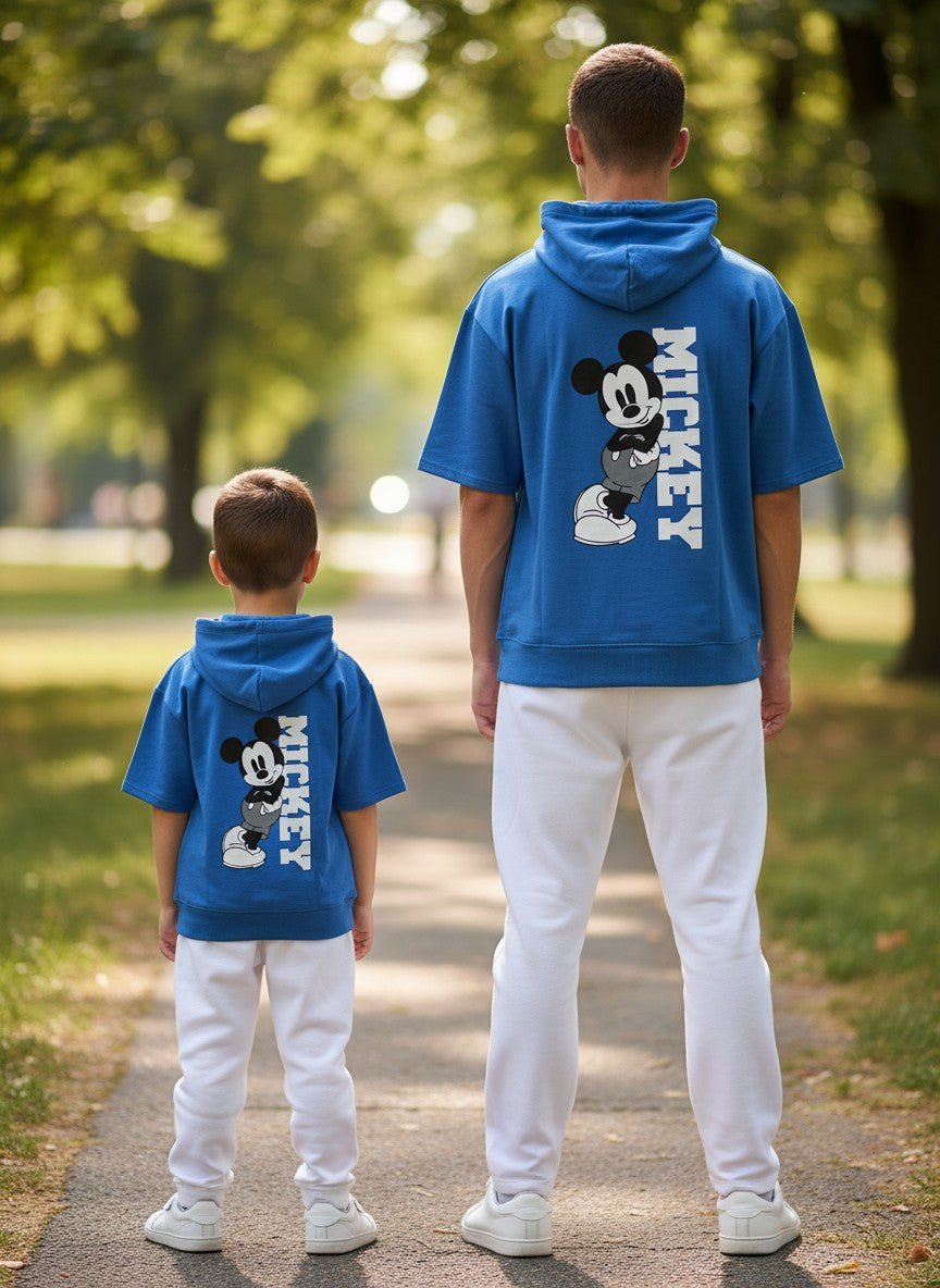Two people wearing blue hoodies with Mickey Mouse designs in a park setting. Antler, Monza Outlet, Monza Fashion, Shein Outlet 