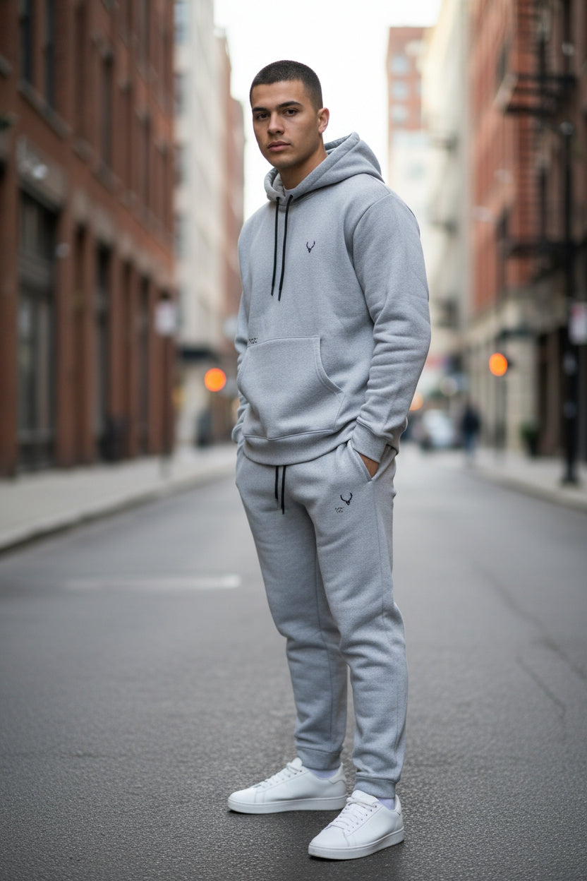Man wearing a gray tracksuit standing on an urban street. Antler, Monza Outlet, Monza Fashion, Shein Outlet