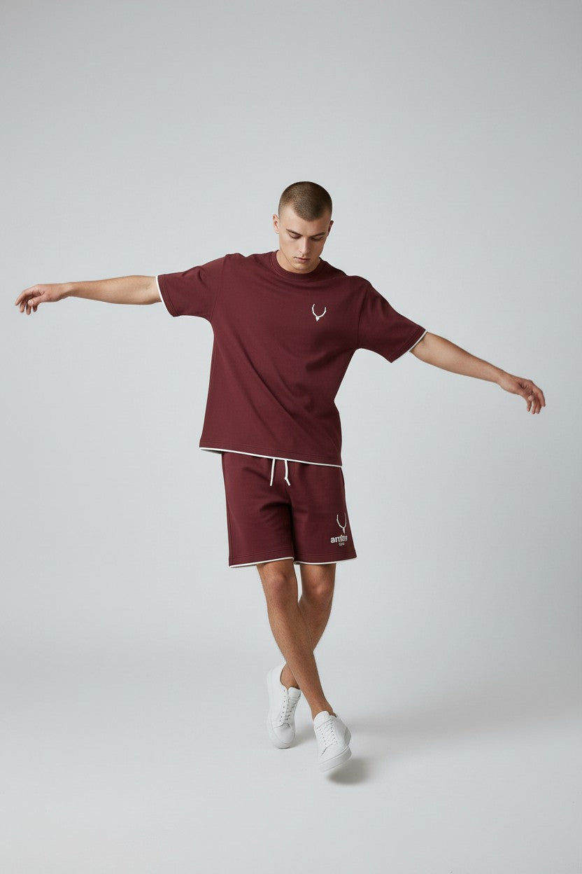 Man wearing a maroon t-shirt and shorts with a logo on a white background. Antler, Monza Outlet, Monza Fashion, Shein Outlet