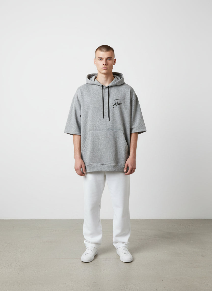 Person wearing a gray hoodie with a logo on a plain background. Antler, Monza Outlet, Monza Fashion, Shein Outlet  