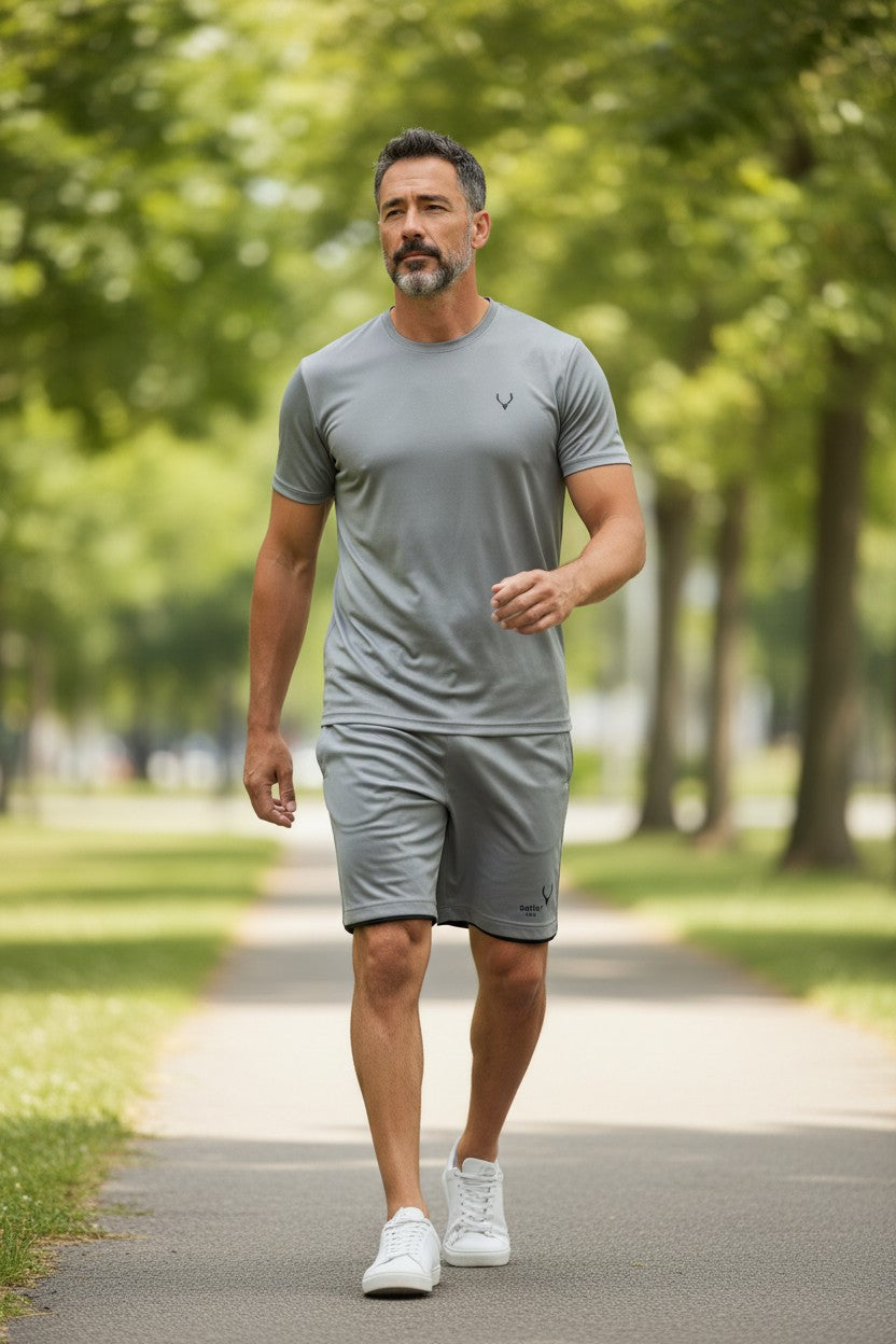 Man in gray athletic wear walking on a path in a park. Antler, Monza Outlet, Monza Fashion, Shein Outlet