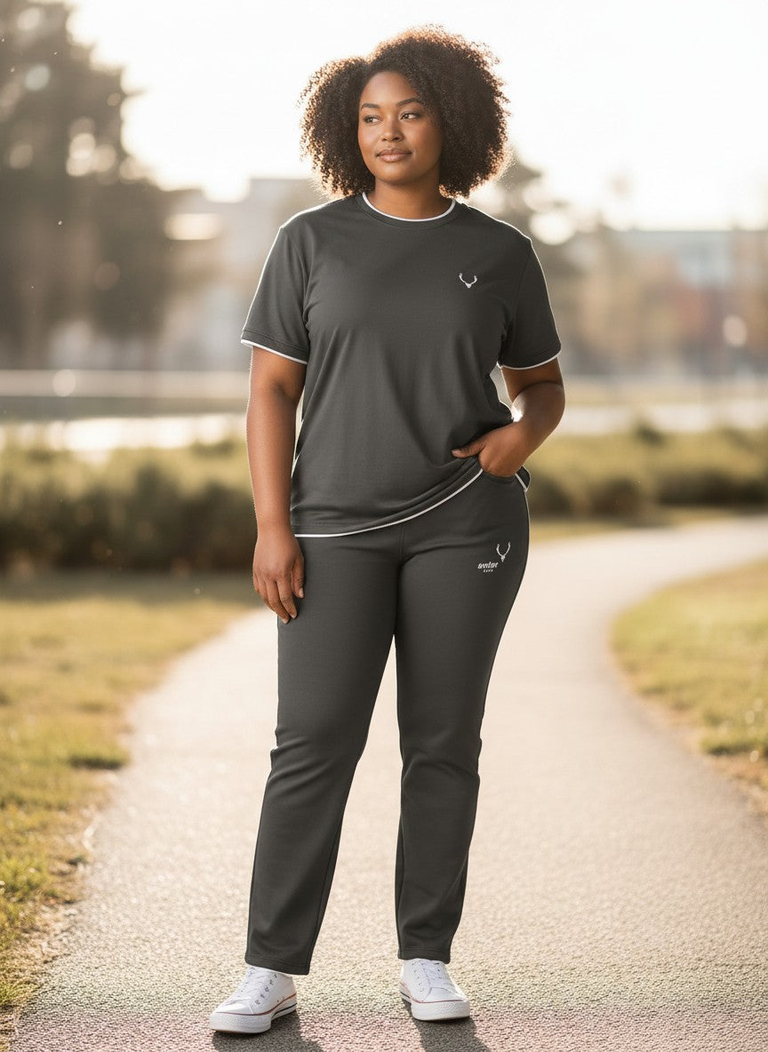 Person wearing a dark gray outfit with a logo on a path outdoors. Antler, Monza Outlet, Monza Fashion, Shein Outlet 