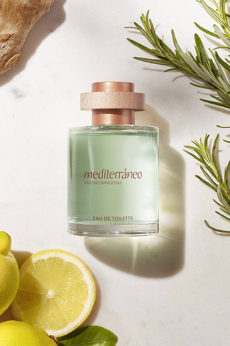 Perfume bottle labeled Mediterraneo with lemons and rosemary on a light background Antonio Banderas Mediterraneo Monza Outlet 