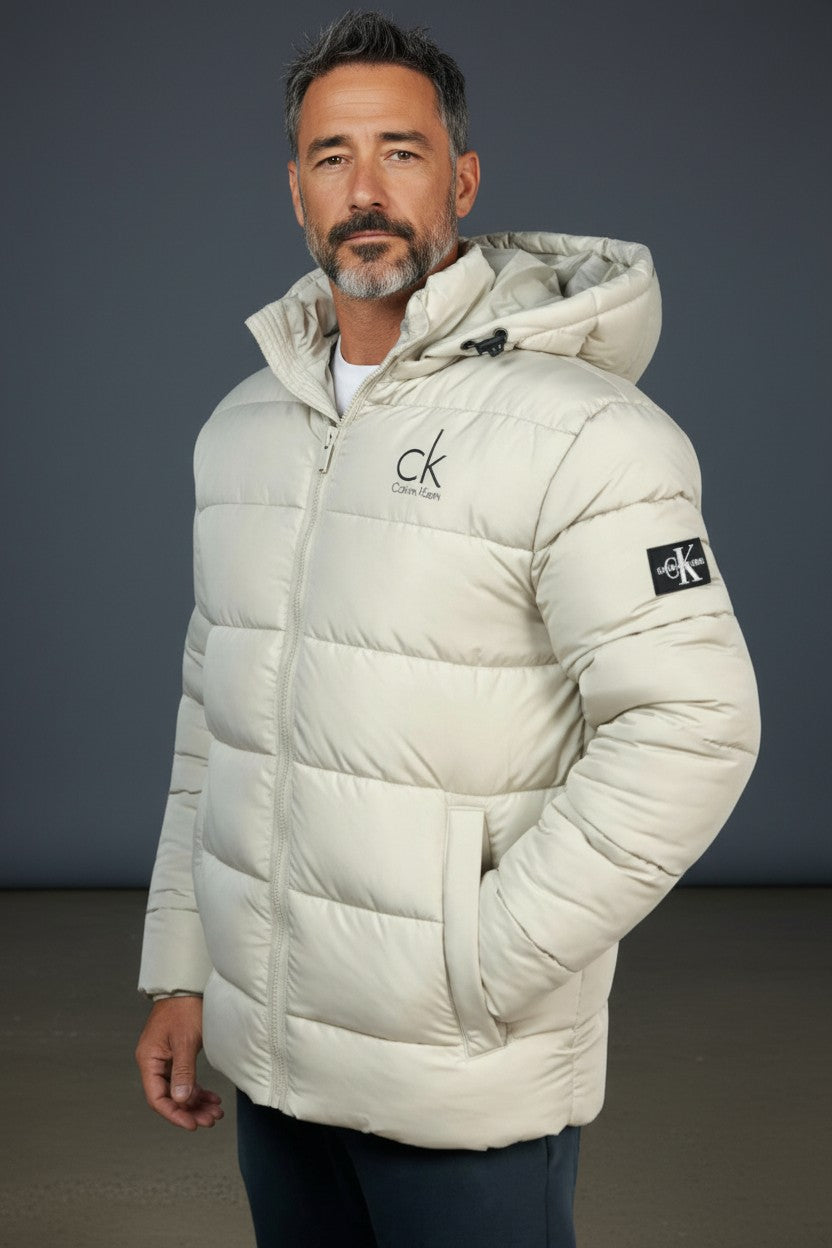 Man wearing a white puffer jacket with a brand logo on a dark background. Calvin Klein, Monza Outlet, Monza Fashion, Shein Outlet