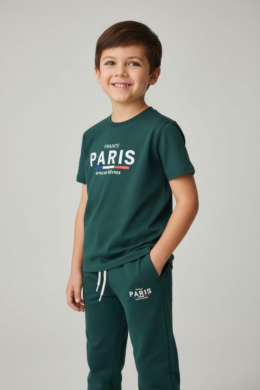 Child wearing a green Paris t-shirt and pants on a gray background. Antler, Monza Outlet, Monza Fashion, Shein Outlet