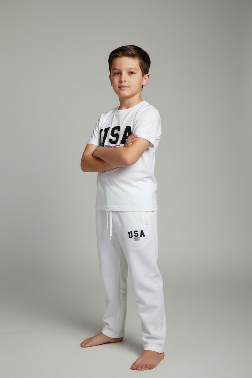 Child wearing a white USA t-shirt and pants on a gray background. Antler, Monza Outlet, Monza Fashion, Shein Outlet